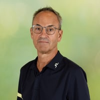Mann mit Brille vor grünem Hintergrund.