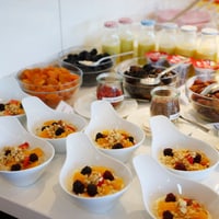 Frühstücksbuffet mit Obst, Joghurt und Säften.