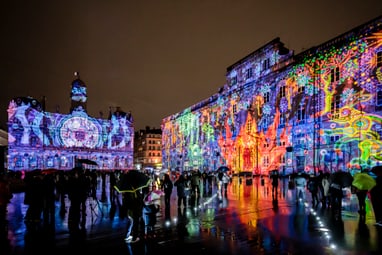 Bunte Lichtprojektionen auf Gebäuden bei Nacht.