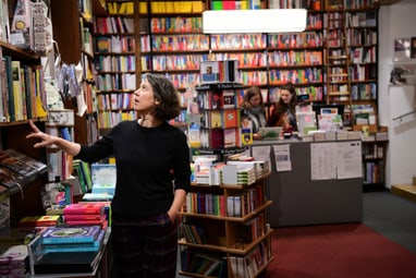 Frau betrachtet Bücher in einer Buchhandlung.