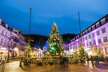 Weihnachtsbaum und Lichter am Abend in einem Stadtplatz.