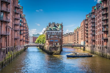 Kanallandschaft mit historischen Backsteingebäuden und Boot in Hamburg.