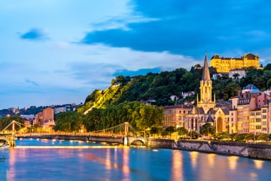 Abendansicht von Lyon mit Fluss, Brücke und Kirche.