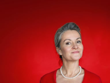 froelein-da-capo.jpg Person in rotem Jäckchen vor rotem Hintergrund.
