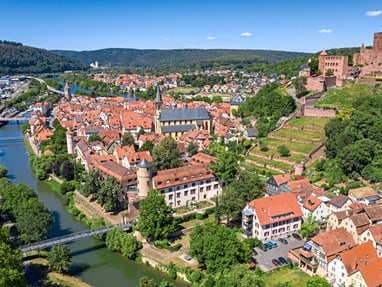 wertheim.jpg Luftbild einer Stadt mit Fluss, Burgruine und roten Dächern.