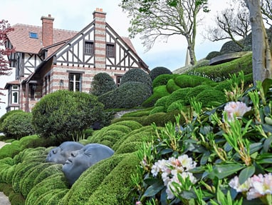 Eindrucksvolles Herrenhaus mit gepflegtem Garten und Kopfbüsten.