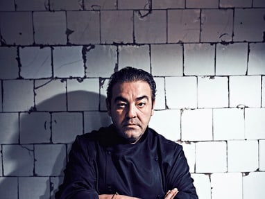 das-excellence-gourmetfestival-10.jpg Mann in dunklem Hemd vor einer gefliesten Wand.