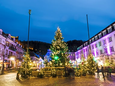 heidelberg.jpg Weihnachtsbaum und Lichter am Abend in einem Stadtplatz.