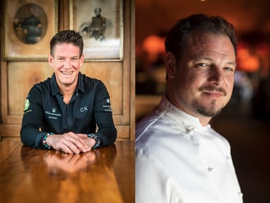 das-excellence-gourmetfestival-10.jpg Zwei Männer, einer in einem dunklen Hemd an einem Tisch, der andere in einem weissen Kochhemd.