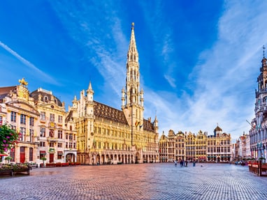 bruessel-grand-place-grote-markt.jpg Historischer Marktplatz mit grossen dekorativen Gebäuden und blauem Himmel.
