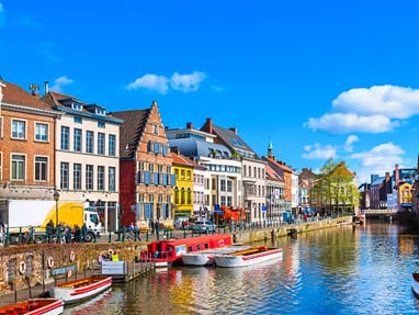 Stadtansicht mit Kanal und bunten Häusern bei klarem Himmel.