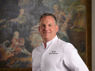 das-excellence-gourmetfestival-10.jpg Person in weissem Hemd vor einem Gemälde.