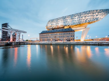 die-hafenmeisterei-antwerpen.jpg Moderne Architektur des Antwerpener Hafenhauses bei Dämmerung.