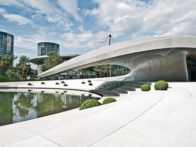 wolfsburg.jpg Moderne Architektur mit gewölbtem Gebäude und Teich im Freien.