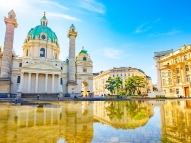 die-karlskirche-eine-der-bedeutendsten-sakralbauten-mitteleu.jpg Barockkirche und Gebäude spiegeln sich in einem Wasserbecken.
