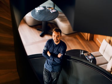das-excellence-gourmetfestival-10.jpg Mann steht in Wendeltreppe, lächelt nach oben.