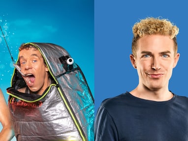 excellence-comedy-cruise-no-4-7.jpg Zwei Männer, einer mit Schlauch, ein anderer im Fischkostüm, daneben ein weiterer Mann vor blauem Hintergrund.