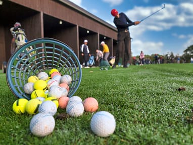 grand-golf-cruise-basel-amsterdam-6.jpg Golfschläge auf einer Driving Range mit verstreuten Golfbällen.