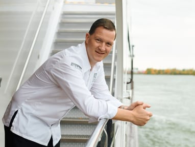 das-excellence-gourmetfestival-10.jpg Mann in weissem Hemd lehnt am Geländer eines Bootes.