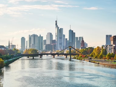 Skyline von Wolkenkratzern hinter Fluss und Brücke bei Tageslicht.