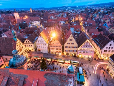 rothenburg-o-d-tauber.jpg Luftaufnahme einer Stadt mit vielen beleuchteten Häusern in der Abenddämmerung.