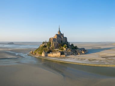 Luftaufnahme einer mittelalterlichen Insel mit umliegendem Sand und Wasser bei Ebbe.