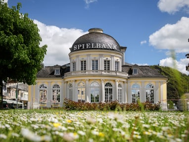 die-weltkulturerbe-stadt-bad-ems-liegt-im-tal-der-lahn.jpg Historisches Gebäude mit Kuppel und Garten im Vordergrund.