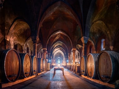 wein-geschichten-und-stille-vereint-im-hospitalkeller-von-kl.jpg Historischer Weinkeller mit Holzfässern und gotischen Bögen.