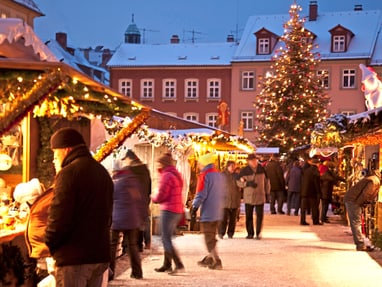bamberg.jpg Weihnachtsmarkt mit Ständen und beleuchtetem Weihnachtsbaum.