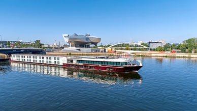 excellence-rhone.jpg Schiff auf einem Fluss vor einem modernen Gebäude.