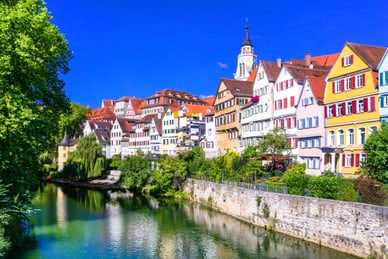 tuebingen.jpg Bunte Altstadthäuser am Flussufer mit Kirchturm im Hintergrund.