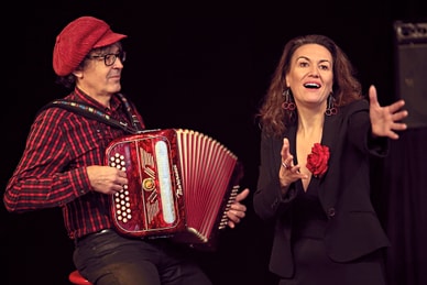 chanson-abend-rendez-vous-avec-piaf.jpg Mann mit rotem Akkordeon und Frau, die gestikuliert.