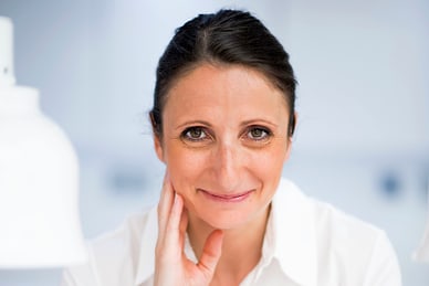 die-koestlichkeiten-des-suedens-2.jpg Frau in weissem Hemd lächelt in hellem Raum.