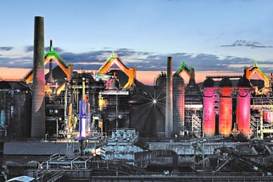 twerenbold_48379.jpg Beleuchtetes Industriegebiet bei Sonnenuntergang.
