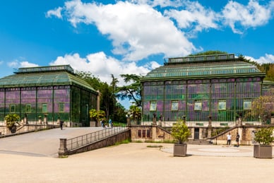 jardin-des-plantes-paris.jpg Zwei grosse, historische Gewächshäuser mit Glasdächern.