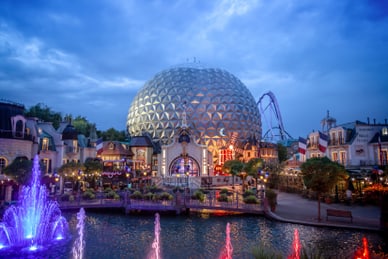 per-schiff-zum-europa-park-1.jpg Beleuchtete Kuppel und Springbrunnen bei Abenddämmerung in Freizeitpark.
