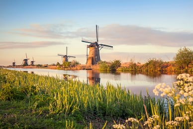 kinderdijk.jpg Windmühlen bei Sonnenuntergang am Fluss.