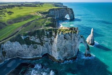 Luftaufnahme der Kreidefelsen von Étretat mit dem Felsbogen Porte d'Aval und der Aiguille-Nadel an der Küste der Normandie.