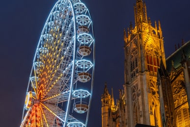 metz.jpg Beleuchtetes Riesenrad neben einer gotischen Kathedrale bei Nacht.