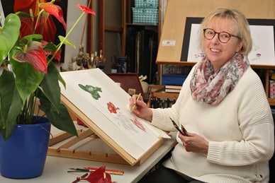 gartenwelten-an-drei-fluessen-2.jpg Frau malt Blumen in einem Atelier.