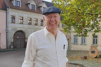 bruno-streit-auslandsschweizer-oekologie-professor-a-d-gibt.jpg Mann mit Mütze auf einem Platz vor alten Gebäuden.
