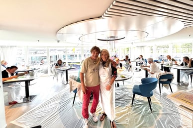 malen-auf-rhein-und-mosel-1.jpg Menschen in einem modernen Restaurant, zwei Personen stehen vorne lächelnd.