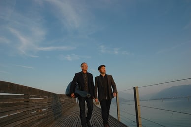 die-cruise-fuer-whisky-lovers-2.png Zwei Männer gehen auf einem Steg am See entlang.