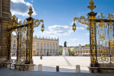 die-saar-und-lothringen-2.jpg Golden verzierter Torbogen mit Blick auf Platz und Statue.
