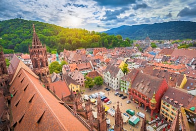goldene-tage-auf-der-crown-2.jpg Luftbild von Freiburg mit historischem Münster und bunten Häusern.