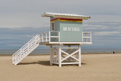 starke-frauen-grosse-geschichten-5.jpg Rettungsschwimmer-Aussichtsturm am Sandstrand mit Meer im Hintergrund.