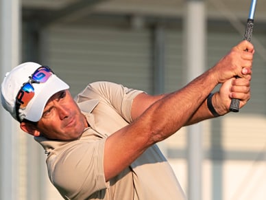 pga-pro-andrea-mantoan.jpg Mann beim Golfschlag mit weisser Mütze und beigem Hemd.