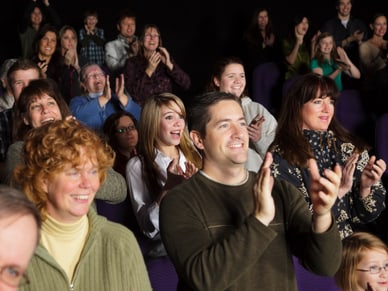 Menschenmenge klatscht in einem Theater.