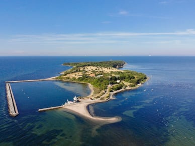 Luftaufnahme der Insel Greifswalder Oie in der Ostsee mit Leuchtturm, Wiesen, Stränden und Anlegesteg.