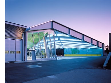Moderne Architektur eines beleuchteten Gebäudes bei Abenddämmerung.